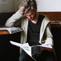 Elite, jongen leest krant